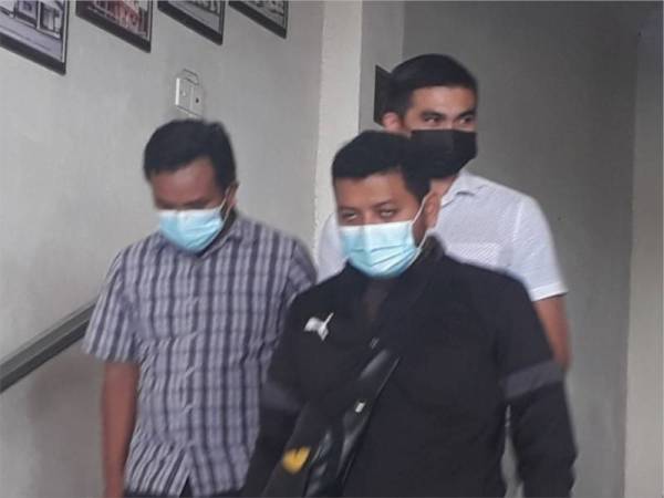 Mohd Saiful (belakang) dibawa anggota SPRM ke kaunter jamin Mahkamah Alor Setar untuk membayar wang jaminan pada Isnin.