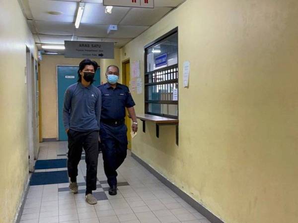 Tertuduh diiringi polis sewaktu hadir di Mahkamah Sesyen Johor Bahru pada Isnin.