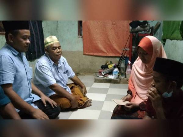 Jasnizam (kiri) hadir menyampaikan sumbangan kepada Sakiroh di di Perumahan KEDA Kampung Semeliang, Kuala Nerang pada Isnin.