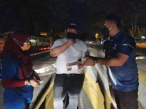 Mohd Nizam(kanan) memberi juadah sahur kepada Razif.