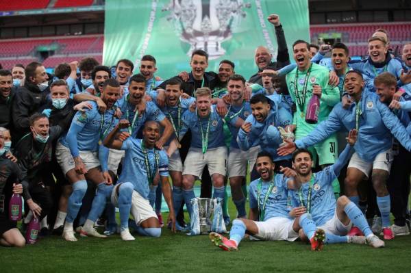 Guardiola bersama barisan pemain dan kejurulatihan City meraikan kejayaan menjuarai Piala Liga di Stadium Wembley pada Ahad.