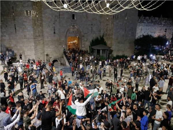 Penduduk Palestin berkumpul berhampiran gerbang Damsyik di Baitulmaqdis pada malam Isnin selepas pertempuran kembali tercetus di kota lama terbabit. - Foto: AFP