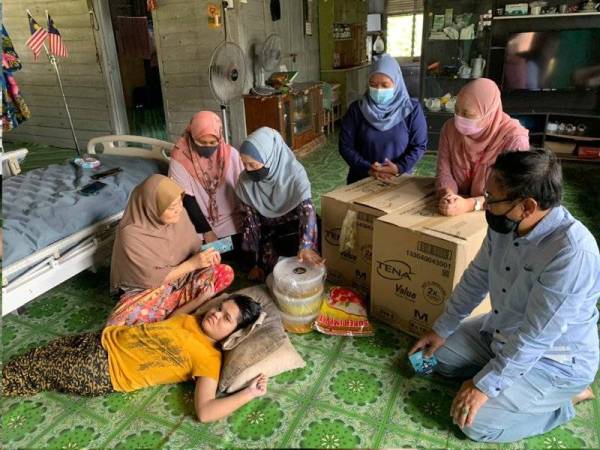 Raja Rusmin (tiga dari kiri) menyampaikan sumbangan kepada Siti Zubaidah ketika berkunjung ke kediamannya di Kampung Pangkal Changgong, Machang pada Rabu.