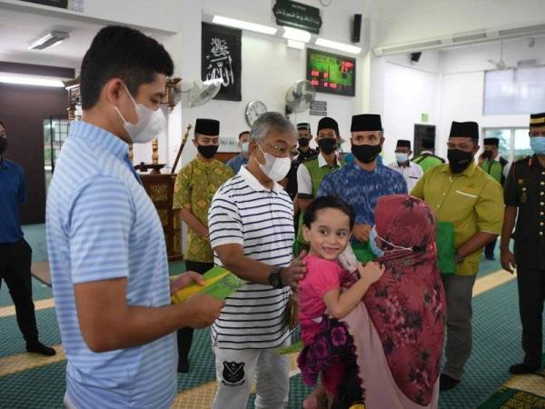 Al-Sultan Abdullah berkenan beramah mesra bersama penerima bantuan semasa menyampaikan sumbangan ketika mencemar duli berangkat ke Program Santuni Kasih dan Kurniaan Daerah Pekan di Masjid Kampung Batu, Pekan pada Rabu. - Foto Bernama