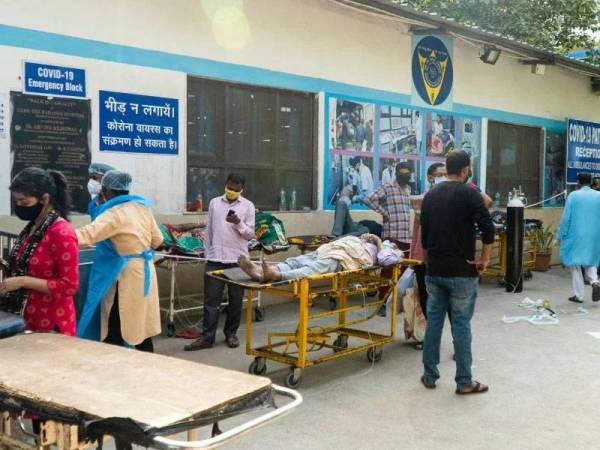 Seorang lelaki menunggu untuk mengisi semula tabung oksigen untuk pesakit Covid-19 di stesan pengisian semula gas tersebut di Allahabad, India pada 24 April lalu. - AFP