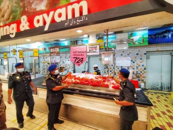 Shamsul Nizam (tengah) memeriksa harga ayam yang dipamerkan di sebuah pasar raya di Alor Setar ketika membuat pemantauan harga sempena SHMMP 2021 pada Khamis.