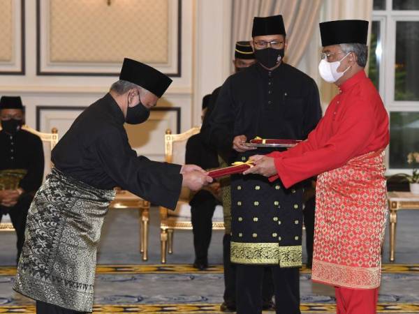 Al-Sultan Abdullah (kanan) berkenan mengurniakan watikah pelantikan kepada Abdul Aziz sempena Hari Nuzul Al-Quran di Istana Negara pada Khamis. - Foto Bernama