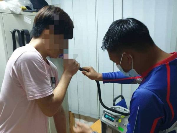 Polis sedang menguji tahap kandungan alkohol salah seorang pemandu yang ditahan. - Foto Ihsan polis