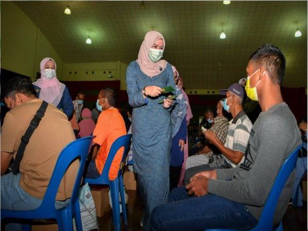 Rina(tengah) menyampaikan duit raya kepada penerima sumbangan pada majlis Penyampaian Makanan 'Bakul Permai' di Kolej Kemahiran Tinggi Mara dekat Masjid Tanah, hari ini.