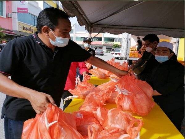 Kakitangan MG Coop Mart menyusun ayam untuk diagihkan secara percuma kepada pelanggan pasaraya itu di Indera Mahkota pada Sabtu.