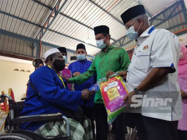 Syed Ibrahim (kanan) dan Abdul Hamid(dua dari kanan menyampaikan bantuan kepada penerima.