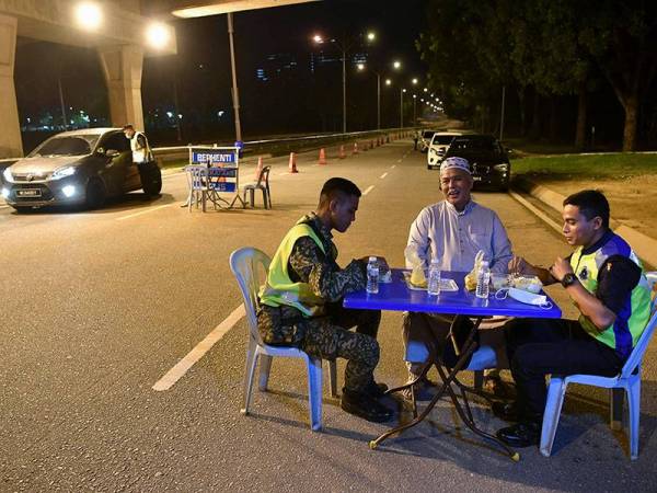 Ketua Polis Daerah Putrajaya, ACP Mohd Fadzil Ali menyantuni petugas barisan hadapan keselamatan menikmati juadah sahur semasa mengadakan sekatan jalan raya di Lebuh Sentosa Presint 7 menghala Lebuhraya Maju Expressway (MEX) awal pagi hari ini.