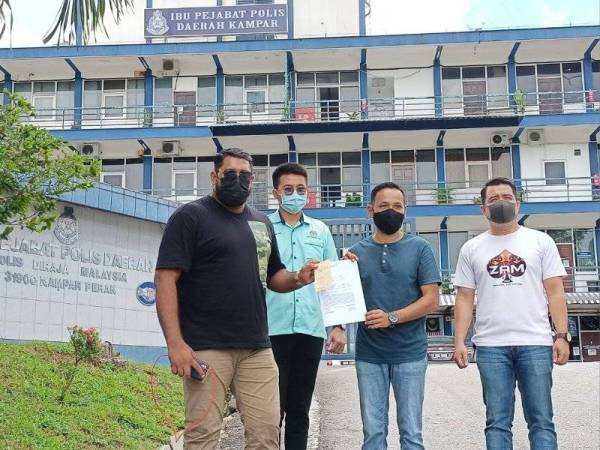Mohammed Hafiz (kiri) selepas selesai membuat laporan polis di IPD Kampar pada Ahad.