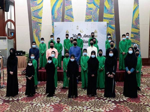 Mohamed Rafik (barisan ketiga, tiga dari kiri) bersama anak-anak yatim dari Rumah Bakti Nur Ain, Bangi yang diraikan pada Majlis Amal Nur Kasih Ramadan di MHS baru-baru ini.