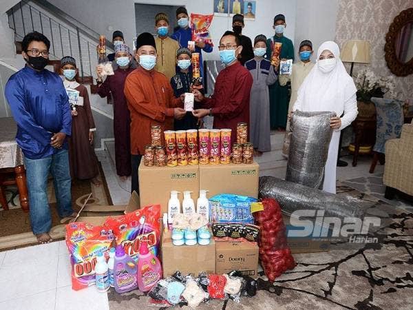 Norshahila (kanan) bersama suaminya, Mohamad Sani Ahmad Bakhir (dua dari kanan) menyampaikan sumbangan kepada Pengetua Baitul Ulfah, Mohd Uzat Omar di Pertubuhan Kebajikan dan Pendidikan Baitul Ulfah, Seri Kembangan pada Sabtu.