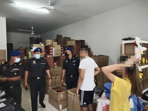 Anggota penguat kuasa KPDNHEP Melaka menyerbu sebuah rumah di Krubong yang dijadikan lokasi menyimpan serta menjual kasut dan selipar tiruan pada Isnin