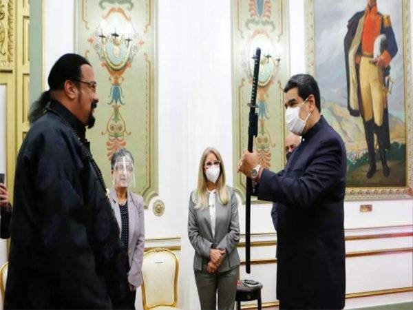 Presiden Venezuela, Nicolas Maduro (kanan) memegang sebilah pedang samurai yang dihadiahkan oleh bintang Hollywood, Steven Seagal (kiri) di pejabatnya di Caracas pada Selasa. - Foto AFP