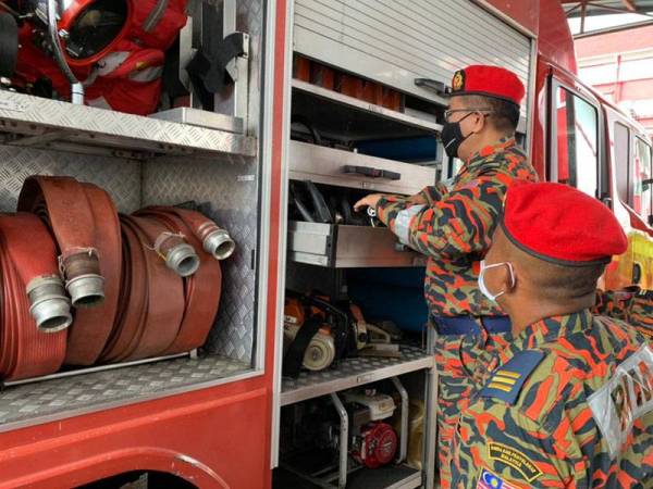 Jainal (dua dari kanan) meluangkan masa memeriksa jentera yang ada di Balai Bomba Tunjong, di Kota Bharu pada Rabu.