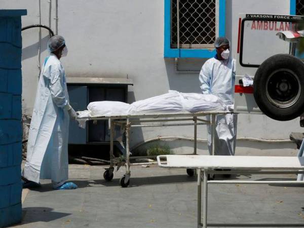 Mayat mangsa Covid-19 dibawa ke ambulans untuk pembakaran mayat di sebuah hospital di New Delhi, India pada Rabu. - Foto Reuters