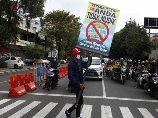 Relawan mengusung poster bertuliskan Terima Kasih Anda Tidak Mudik saat aksi di Jalan Slamet Riyadi, Solo, Jawa Tengah pada Rabu. - Foto Agensi