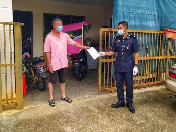 Pihak polis menyerahkan kompaun kepada lelaki terbabit pada Khamis selepas ingkar SOP dan gagal kuarantin kendiri di rumah. - Pic ihsan PDRM