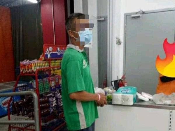 Tular gambar lelaki yang memakai gelang merah jambu terbabit sedang membuat pembayaran di kaunter pasar raya.