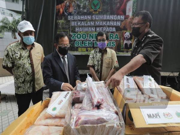 Ahmad Hamzah (dua dari kiri) melihat bekalan daging untuk diserahkan kepada Zoo Negara di Wisma Tani, Putrajaya pada Khamis.