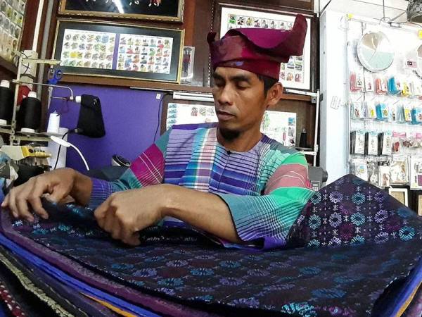 Mohd Iskandar menyiapkan tanjak yang ditempah pelanggan.