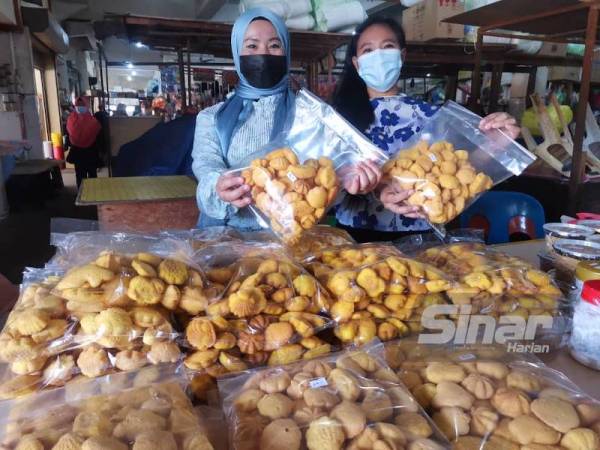 Noorsyakella (kanan) dan kakaknya, Suhana (kiri) menunjukkan bahulu yang dijual mereka di Pasar Am Beaufort.