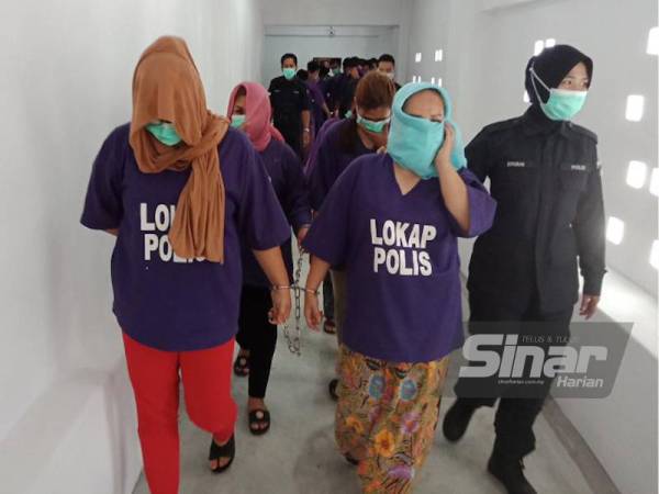 Datin berusia 48 tahun (tengah) bersama tiga lagi wanita dipercayai ahli geng Sindiket Datin dikawal ketat polis ketika dibawa ke Mahkamah Kota Bharu bagi mendapatkan perintah tahanan reman.
