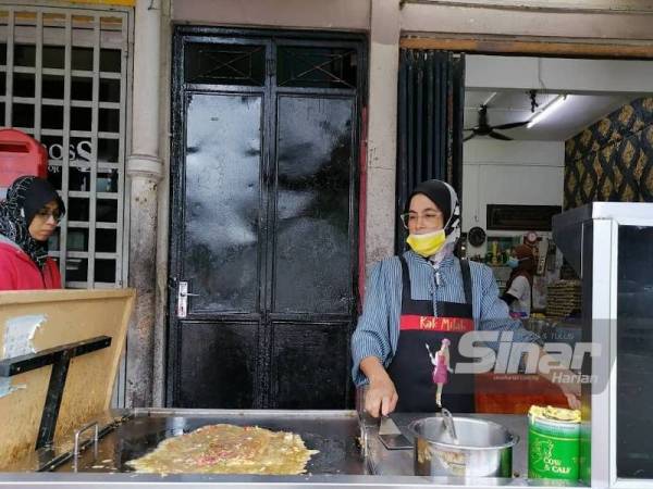 Kak Milah menyiapkan martabak opor yang ditempah pelanggan.