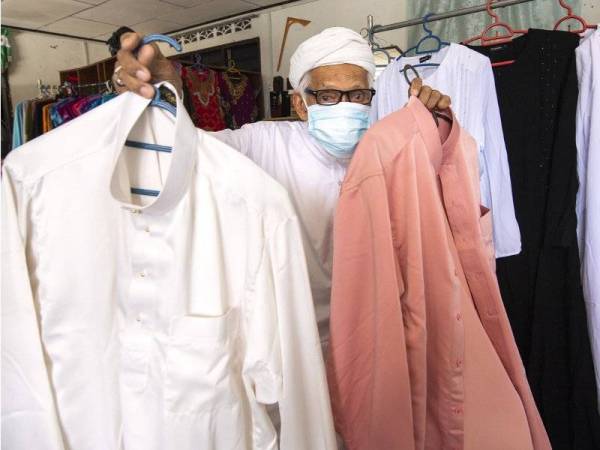 Che Hamat menujukkan baju Melayu pelanggannya yang telah siap ketika ditemui di kedai jahitnya Harison Style di Kampung Kubang Cherang, Wakaf Che Yeh. - Foto Bernama