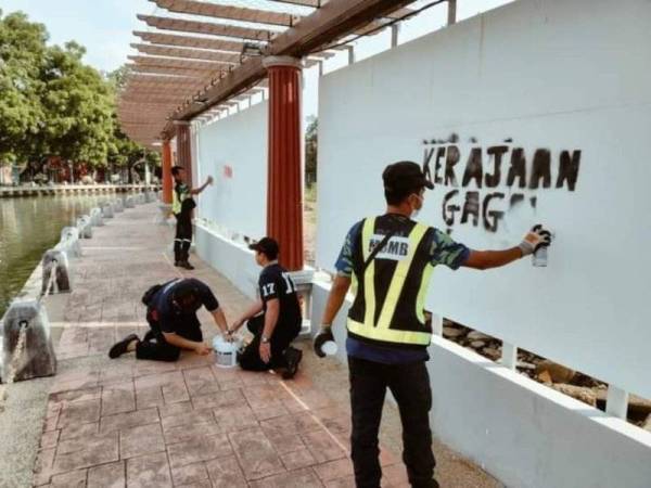 Beberapa pekerja MBMB sedang mengecat semula panel iklan di sekitar Sungai Melaka.