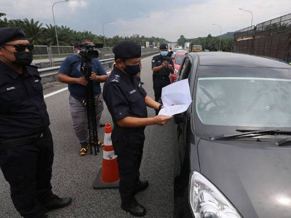 Mohd Nadzri membuat pemeriksaan surat rentas negeri pengguna jalan raya yang melalui Lebuh Raya PLUS di Seremban pada Selasa.