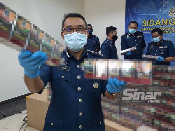 Abdul Halim (depan) menunjukkan rokok seludup yang dirampas dalam dua serbuan di Pelabuhan Klang, Selangor.