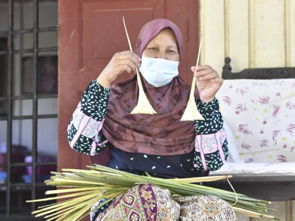 Habsah menunjukkan sarung ketupat yang sudah siap di rumahnya di Kampung Paya Ular, Pasir Mas.