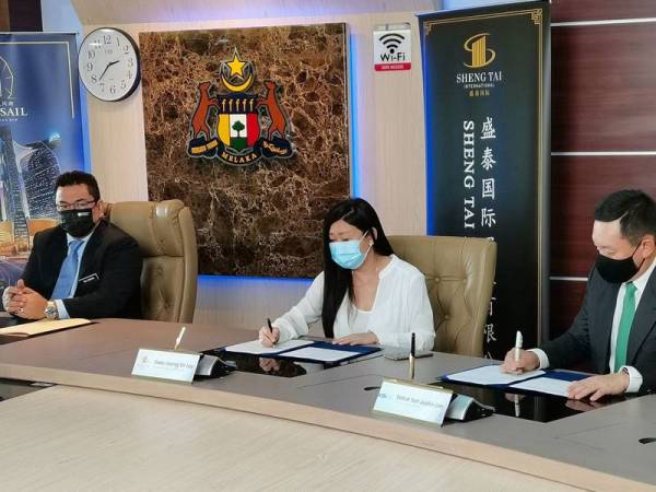 Sir Ley (tengah) dan Justin Lim menandatangani MoA yang disaksikan Ketua Menteri Melaka, Datuk Seri Sulaiman Md Ali (kiri).