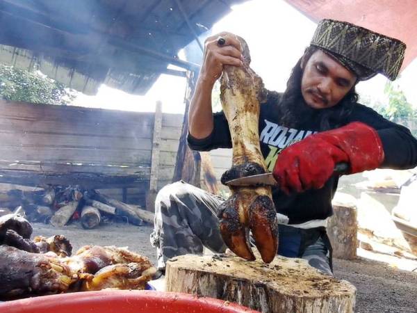 Syed Afindi bersihkan kaki lembu yang telah siap dibakar sebelum disimpan di dalam peti untuk menghasilkan daging yang rangup.
