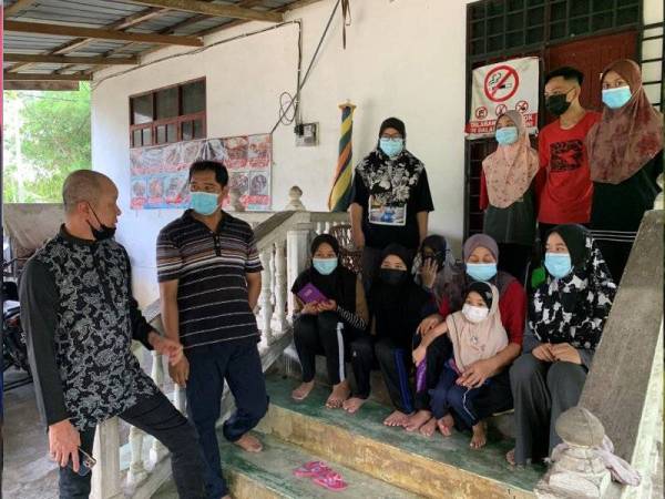 Ahli perniagaan, Datuk Seri Sunny Ung (kiri) berbual dengan Mohd Azizi Mohd Nor ketika melawat keluarga berkenaan di Kampung Chekok Tengah di sini pada Rabu.