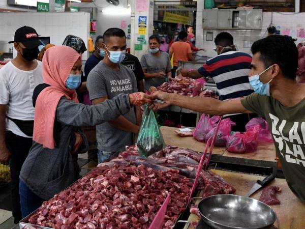 Orang ramai membeli daging di Kompleks Pasar dan Kemudahan Masyarakat Bayan Baru sebagai persiapan akhir bagi menyambut Aidilfitr . Foto: Bernama