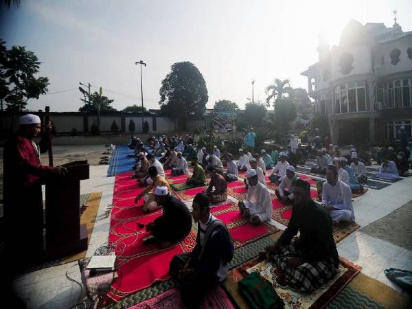 Pelajar madrasah mendengar khutbah selepas menunaikan solat sunat Aidilfitri dengan mengamalkan penjarakan sosial bagi mematuhi prosedur operasi standard (SOP) yang telah ditetapkan oleh Majlis Keselamatan Negara dan Kementerian Kesihatan Malaysia bagi mengekang penularan wabak COVID-19 ketika tinjauan di Madrasah Darussolihin Kampung Jalan Kebun Seksyen 30 hari ini. - Foto Bernama
