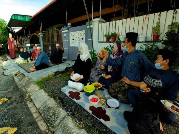 Penduduk Taman Medan Klebang Restu meraikan Hari Raya Aidilfitri dengan menikmati juadah Aidilfitri di hadapan rumah masing-masing sambil beramah mesra bersama jiran tetangga tanpa aktiviti ziarah menziarahi ketika tinjauan Bernama di Klebang hari ini. - Foto Bernama