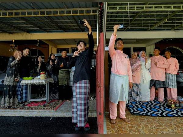 Penduduk Taman Medan Klebang Restu, Muhd Asyraf Fakhirol Azman, 29, (lima, kanan) dan Muhd Nor Hakeem Kamarol Baharin, 21, (enam, kanan) bergambar bersama keluarga ketika meraikan Hari Raya Aidilfitri dengan menikmati juadah Aidilfitri di hadapan rumah masing-masing sambil beramah mesra bersama jiran tetangga tanpa aktiviti kunjungan ziarah menziarahi ketika tinjauan Bernama di Klebang hari ini. - Foto Bernama