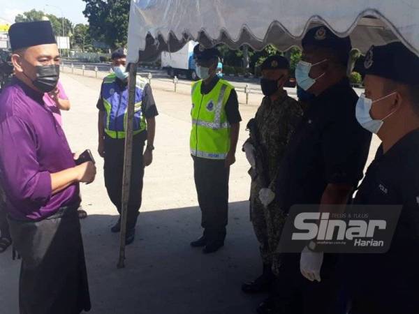 Ahmad Shukri (kiri) mengucapkan selamat hari raya kepada anggotanya yang bertugas pada 1 Syawal di SJR Tol Setar Utara pada Khamis.