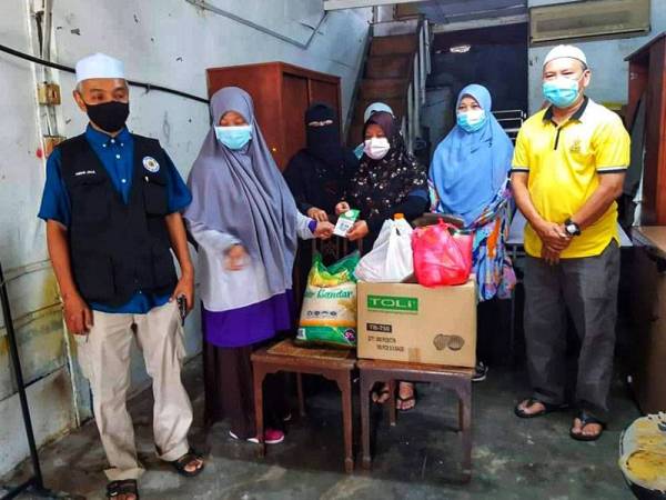 Wakil LZS menyantuni Nur Hidayah (tiga dari kanan) yang tinggal di dalam stor seperti dilaporkan dalam sebuah portal berita Jumaat lalu.