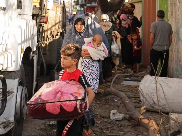 Keluarga Palestin terpaksa meninggalkan kediaman mereka di Bandar Gaza untuk berlindung di kawasan lebih selamat selepas Israel memperhebatkan kempen pengeboman mereka di wilayah itu. - Foto AFP