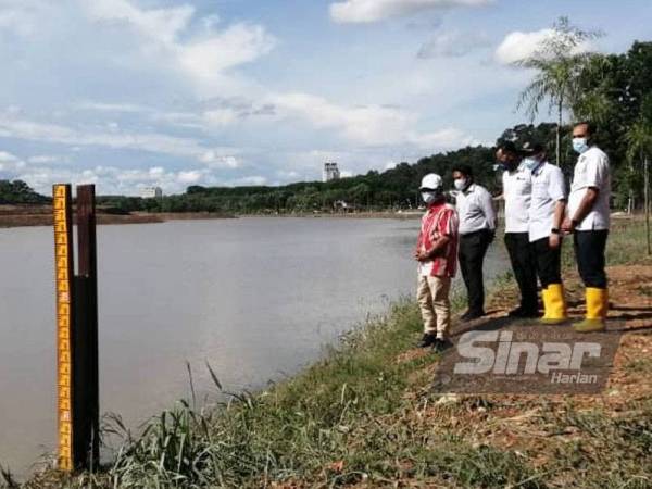 Idris (kiri) meninjau Kolam Takungan Banjir Sungai Putat yang kembali sedia kala selepas banjir yang melanda.