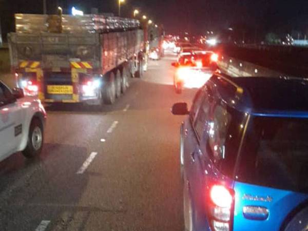 Takungan air di lebuh raya berhampiran susur keluar Jalan Kuala Kangsar menyebabkan kesesakan lalu lintas. Foto: ihsan pembaca