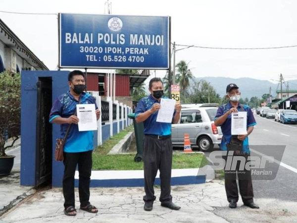 Jaafar (tengah) membuat laporan polis berhubung mesej palsu penutupan pasar malam dalam tempoh PKP di Balai Polis Manjoi.