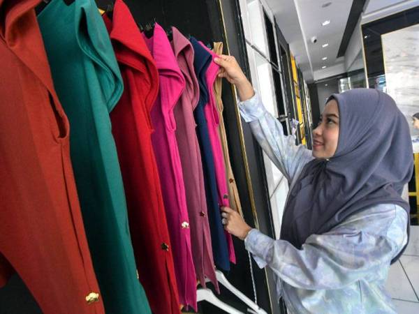 Che Nurul Hafizah menyusun koleksi tudung yang dijualnya ketika ditemui di butik By Chefiza miliknya di Lembah Sireh. Foto Bernama